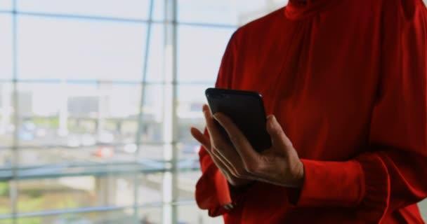 高加索女商人在办公室使用手机的中间部分。她正在发短信
