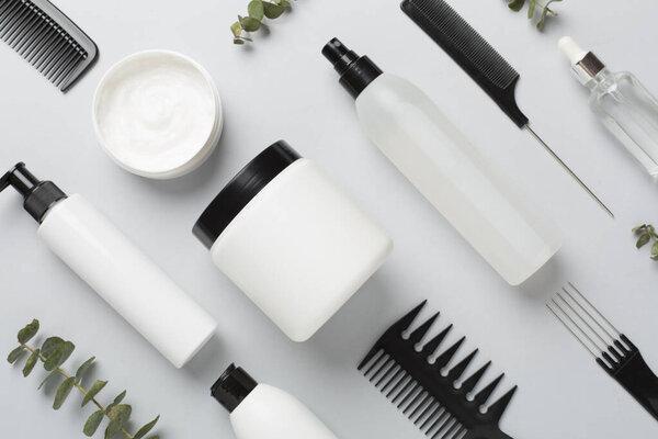 Professional hair care products with comb on color background, top view
