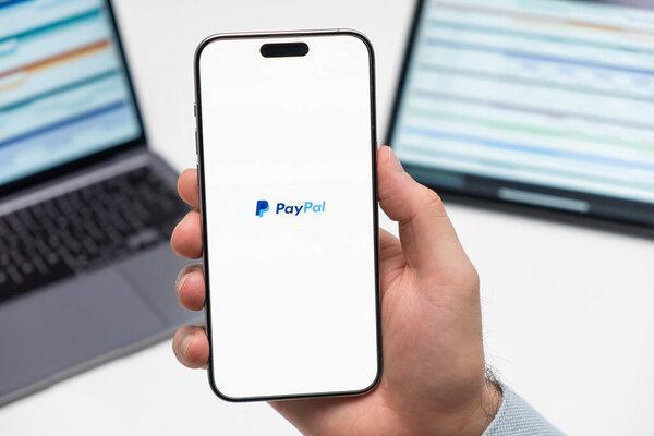 白羊座，CZECH - JANUARY 21 2024：职场背景下男性智能手机屏幕上的PayPal标志. 