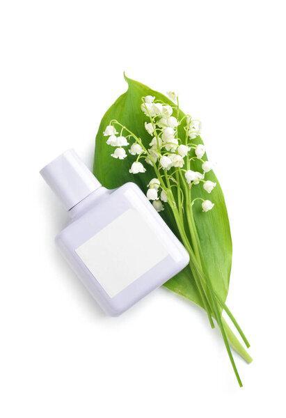 Bottle of perfume and lily-of-the-valley flowers on white background