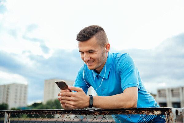 Smiling guy looking into cell phone with headset