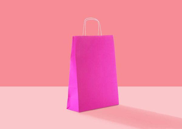 Pink paper bag on color background. Mockup for design