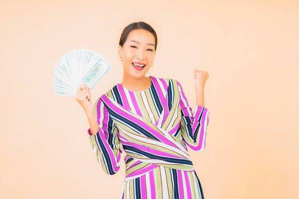 亚洲年轻貌美的女性形象，身披现金或金钱，手持智能手机，背景与肤色无关