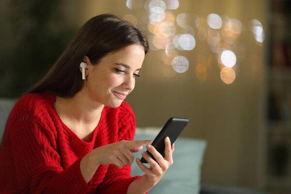 Woman in red listening to music at home in the night
