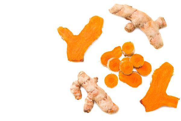 Turmeric root with turmeric slices isolated on white background. Top view.