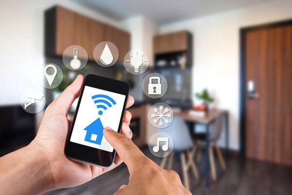Hand using smartphone by app smart home on mobile for remote control everything in home by wifi network.