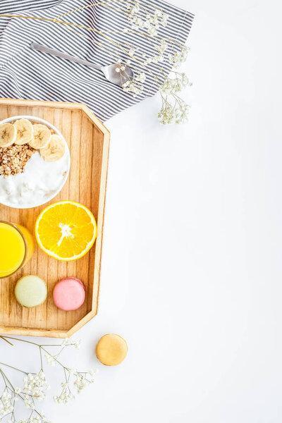 Healthy granola, macaroons and orange juice for colorful breakfast on white background top view mock-up