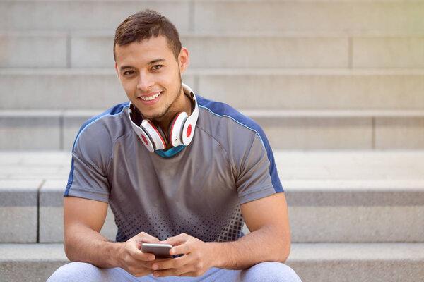 Listening to music young latin man listen headphones smiling cop