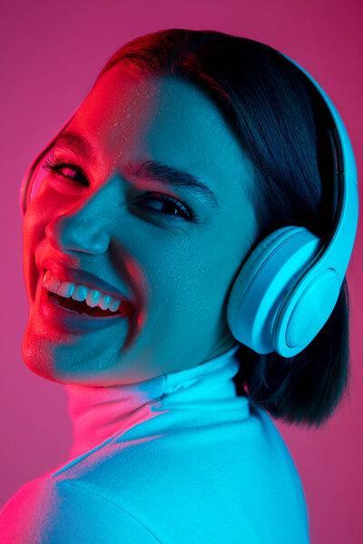 Caucasian womans portrait isolated on pink studio background in multicolored neon light