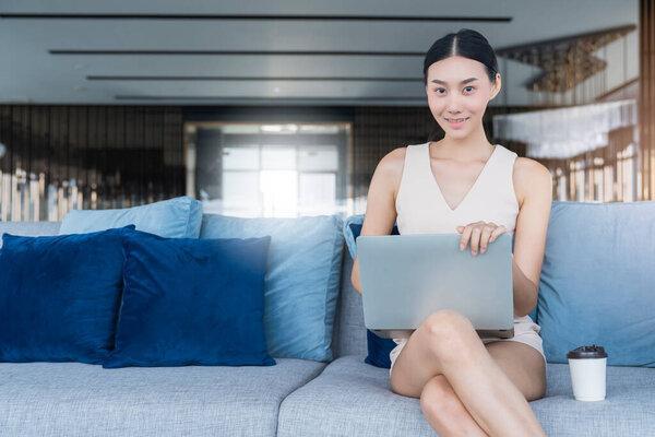 cheerful attractive female woman happiness joyful hand hold laptop smartphone credit card shopping online from home white quarantine social distancing in covid-19 corona virus spread outbreak