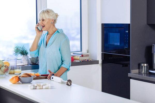 Delighted cheerful woman doing a phone call