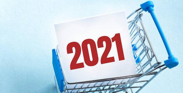 Text 2021 on the notepad in the shopping cart. BUSINESS CONCEPT