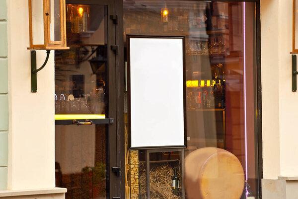Rectangular sign on the building. Copy space and space for text. Mockup for design. Blank template for advertising. White frame on a glass case. Advertising on the window of a restaurant or shop.