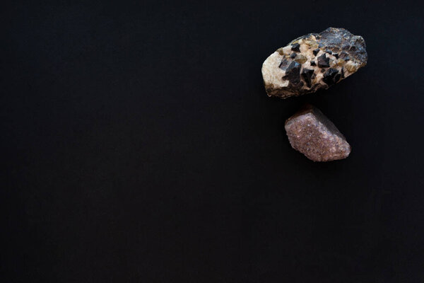 Two large crystal stones on a black paper background. Mockup, copy space. 