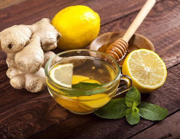 Ginger tea with lemon honey and mint on wooden background