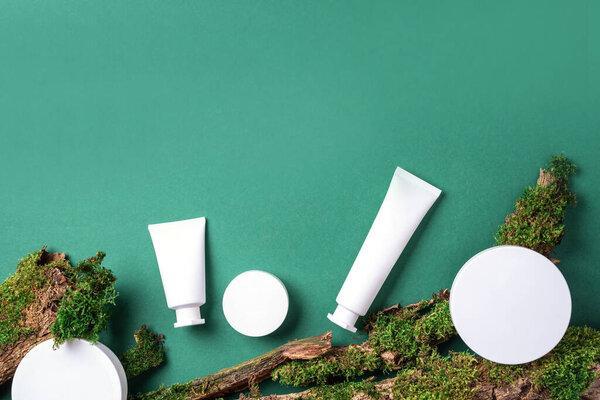 Cream jar, moisturizing lotion, shampoo or other cosmetic product in white blank bottle on green background with moss, tree bark. Skin care, organic body treatment, spa concept. Vegan eco friendly.