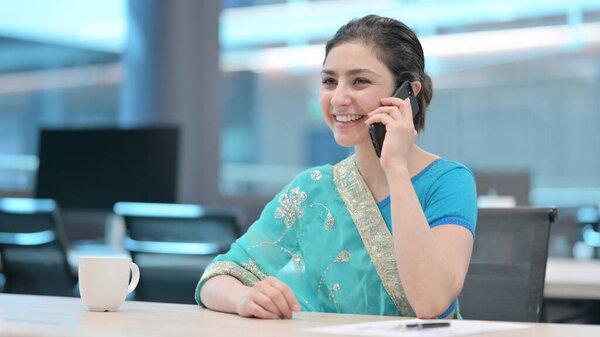 Young Indian Woman Talking on Smartphone at Work
