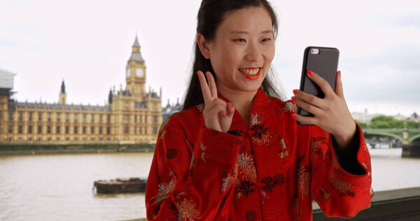 快乐的千禧年妇女采取自拍与智能手机在伦敦英国