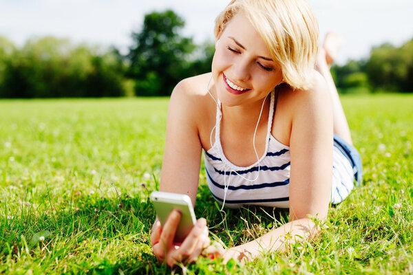 Woman on grass listening to music