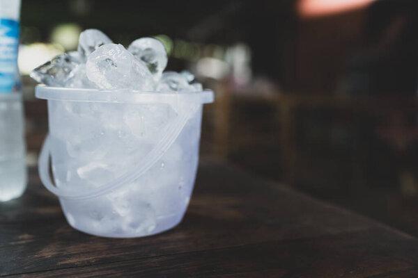 木桌上的透明塑料桶里装满了冰块