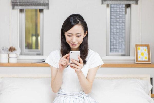 年轻漂亮的女人在家里用电话 
