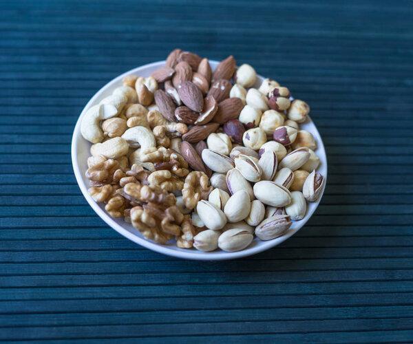 Healthy food. Nuts mix assortment on stone texture top view. Collection of different legumes for background image close up nuts, pistachios, almond, cashew nuts, peanut, walnut. image