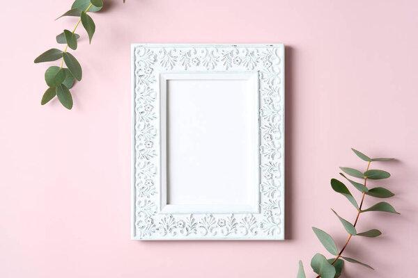 Photo frame mockup and eucalyptus leaves on pink background. Happy Mothers Day, love, romance concept.