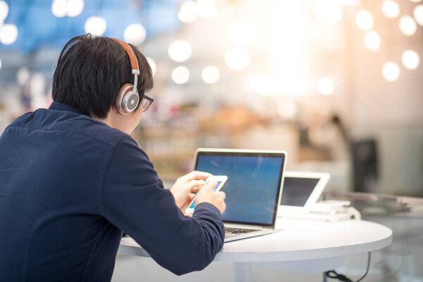 Young Asian business man listening to music while working with l