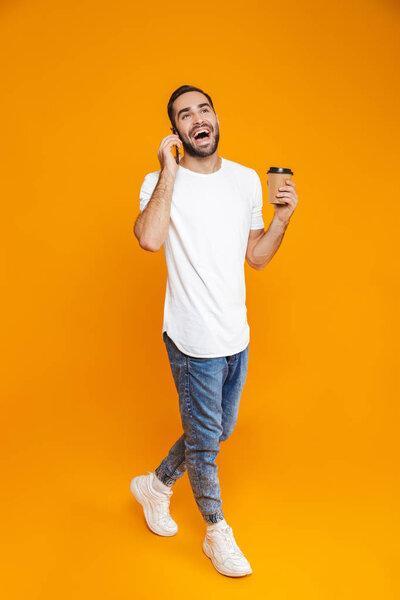 Photo of optimistic man 30s in casual wear speaking on cell phon