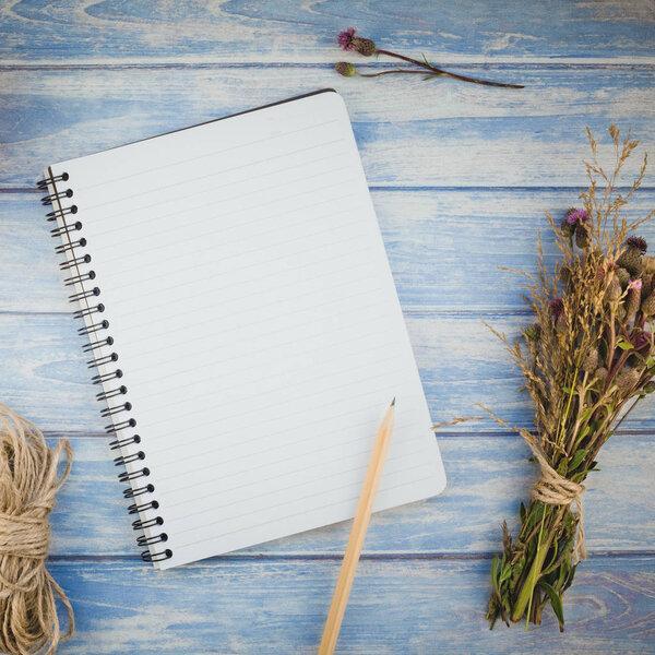 Blank notebook with pencil and autumn flowers 