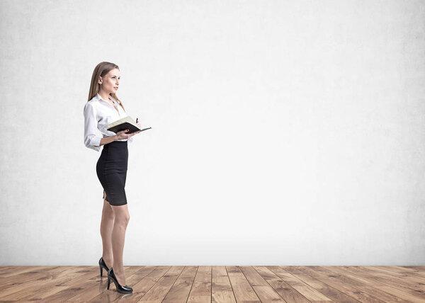 Blonde businesswoman with a notebook, gray