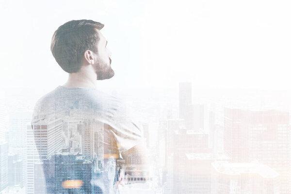 Side view of man looking at cityscape, toned