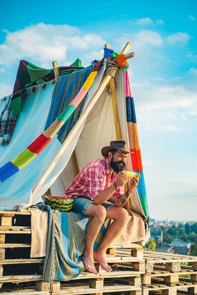 Tourism rest on nature. Handsome bearded man inside camping tent. Go Ape Adventure. Homemade Tent Camping for free man.