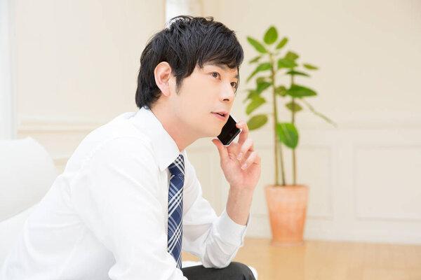 智能手机在沙发上的年轻人 