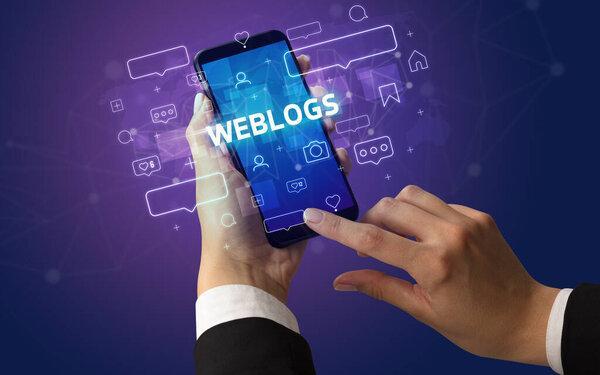 用WEBLOGS字体、社交媒体概念在智能手机上打字的女性