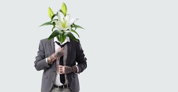 Young businessman with bouquet of flowers instead of his head on light background with space for text