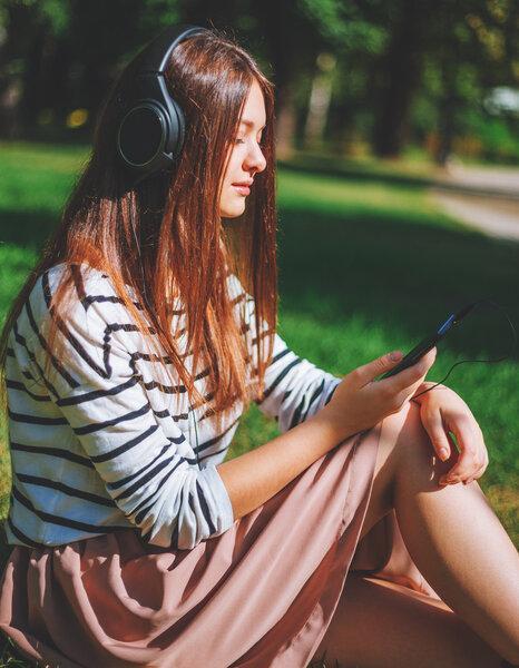 Young girl listening to music in park
