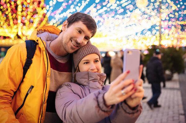 Happy young people take a selfie outdoors during the Christmas days. Valentines Day.