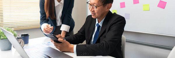 Business partnership concept, Business senior read data on smartphone while discussing with partner.