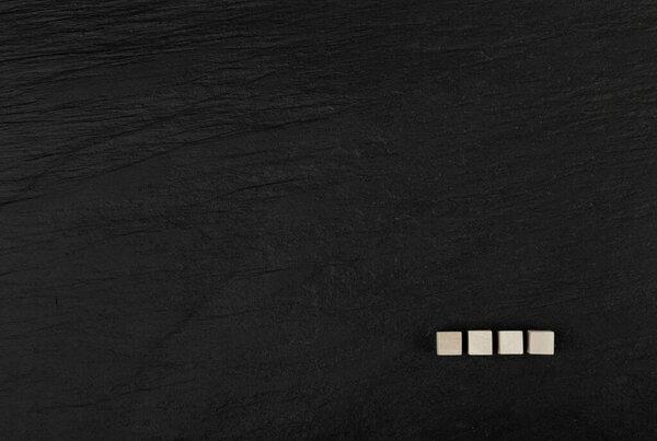 Four Cubes on a Black Stone Background, Word of 4 Letters Mockup, Blank for Advertising Copy Space
