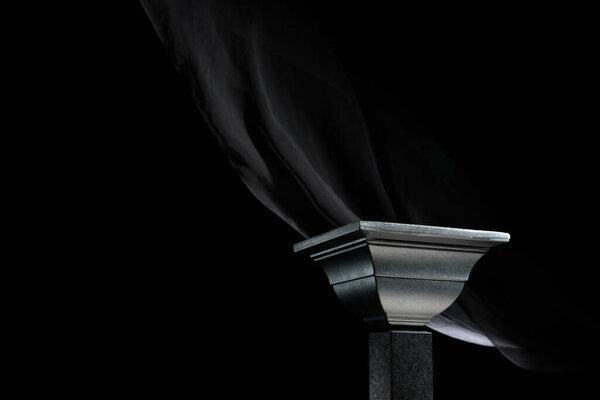 Luxury black podium on a background of waving black silk curtain. Perfect platform for showing your products on a dark background.