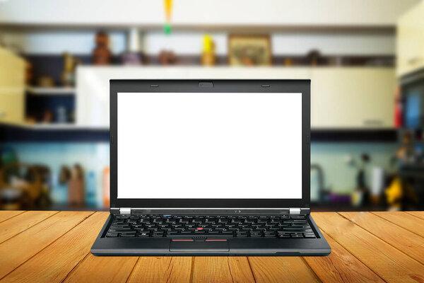 Modern computer,laptop with blank screen on wooden table with blur kitchen backgrounds
