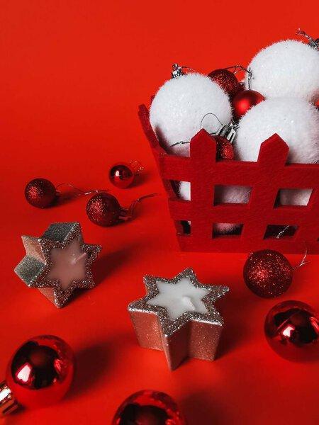 Christmas and New Year decorations on a red background. Festive card with a red background, Christmas tree decorations, candles, holiday decorations for a postcard