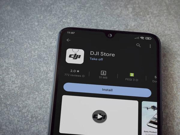 Lod, Israel - July 16,2023: DJI Store app play store page on smartphone on ceramic stone background. Top view flat lay with copy space.