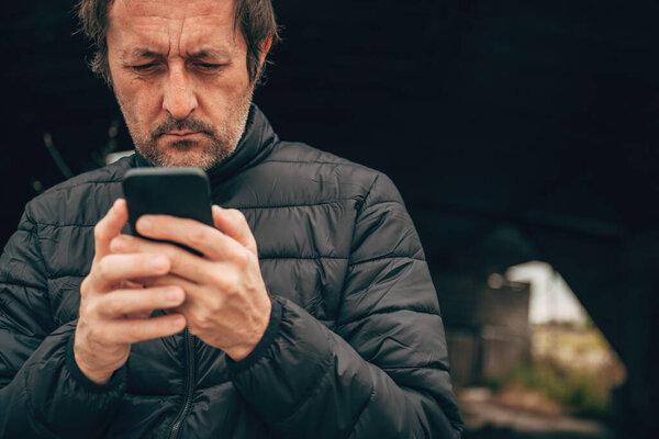， 手机漫游和 eSIM 概念，， 成熟的成年男子在户外使用智能手机，， 选择性聚焦