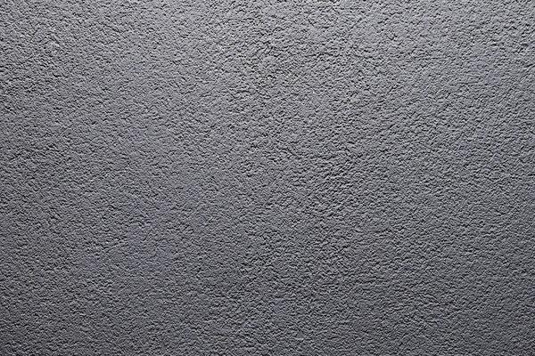 Grey matte stone wall texture. Uneven surface painted in gray colour. Backdrop with irregularities and relief. Horizontal photo.