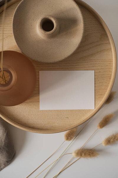 Blank paper sheet card with mockup copy space and rabbit tail grass on wooden casket. Minimal aesthetic business brand, blog, social media template background. Flat lay, top view