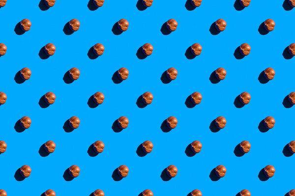 Hazelnuts background. A trendy sunlight pattern made of hazelnuts against a bright blue background. Colorful pattern. Top view