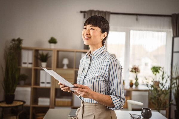 日本妇女在办公室持证件的肖像