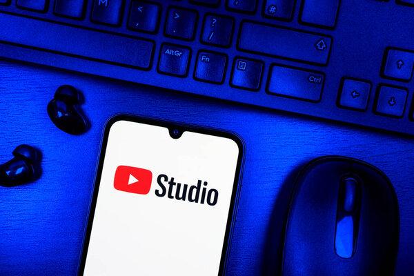 Prague, Czechia - 08 09 2025: A top-down view of a desk with a phone displaying the Youtube Studio logo. Youtube Studio is a platform for managing and analyzing YouTube channels.